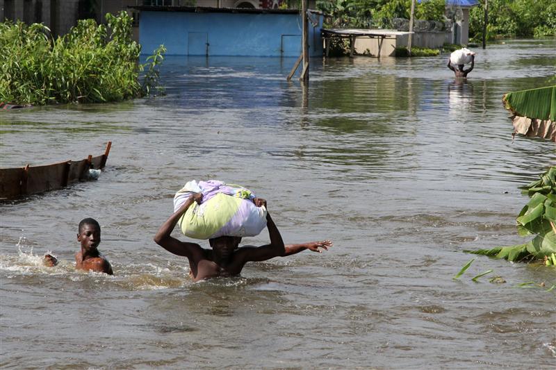 People wade through a flood with their belongings after their houses were submerged in the Amassoma community in Bayelsa state October 6, 2012. REUTERS/Tife Owolabi